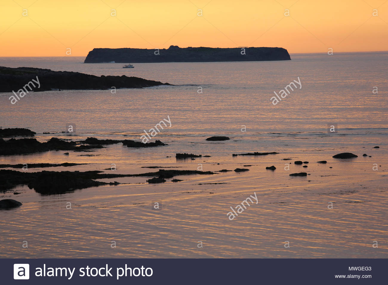 Sonnenuntergang fällt über die sieben Schweine von Inseln vor der Küste von Castlegregory in Irland als ein Schiff Köpfe zum Meer. Stockfoto