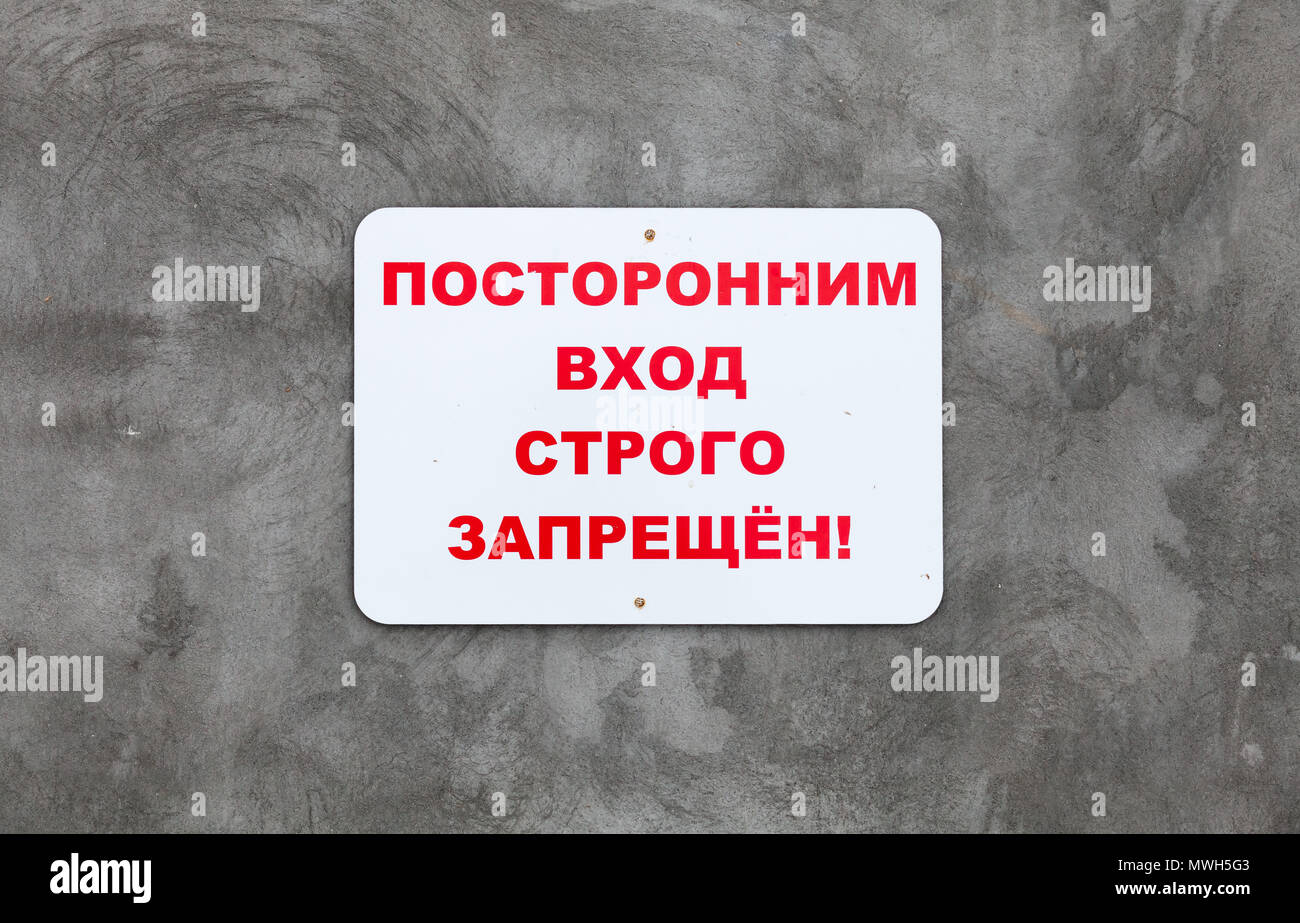 Weiße Platte auf graue Betonwand mit der Inschrift auf Russisch: Unerlaubte Einreise ist strengstens verboten. Stockfoto