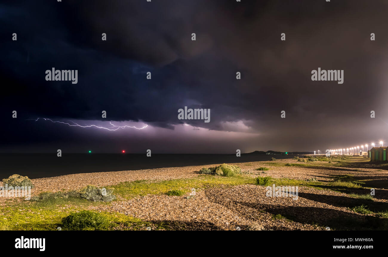 Dunkle schwarze Wolken mit horizontalen Blitz wie ein Gewitter tobt draußen auf dem Meer in der Nacht vor der Südküste in Großbritannien. Sturm auf See. Stockfoto