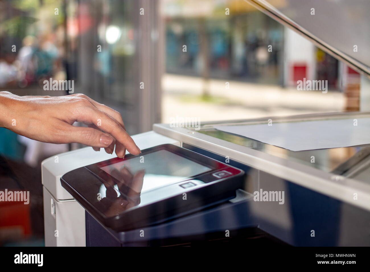 Woman's Hand auf dem Touchscreen des Kopierers auf einer Straße copy Center Stockfoto