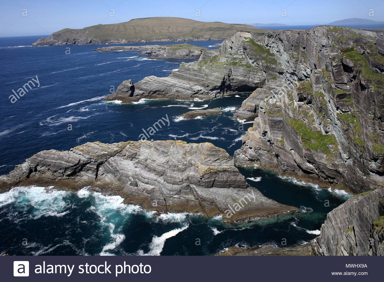 Wellen des Atlantiks Schaumstoff Weiß gegen schroffe Felsen im County Kerry an der Südwestküste von Irland Stockfoto