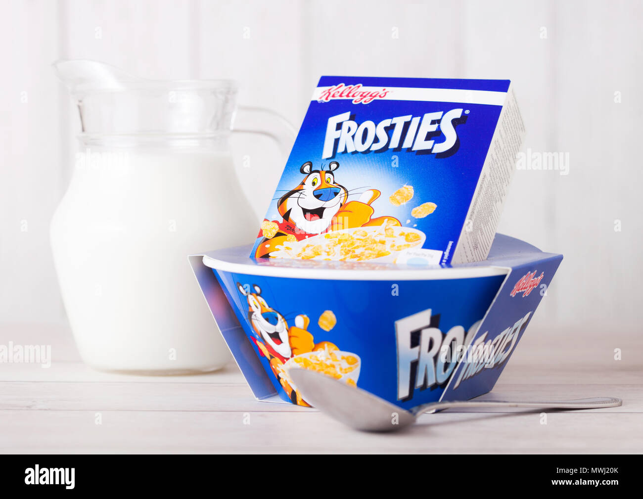 LONDON, UK, 01. Juni 2018: Die Box von Kellogg's Frosties Frühstück Müsli mit Milch und Platte auf weißem Holz- Hintergrund. Stockfoto