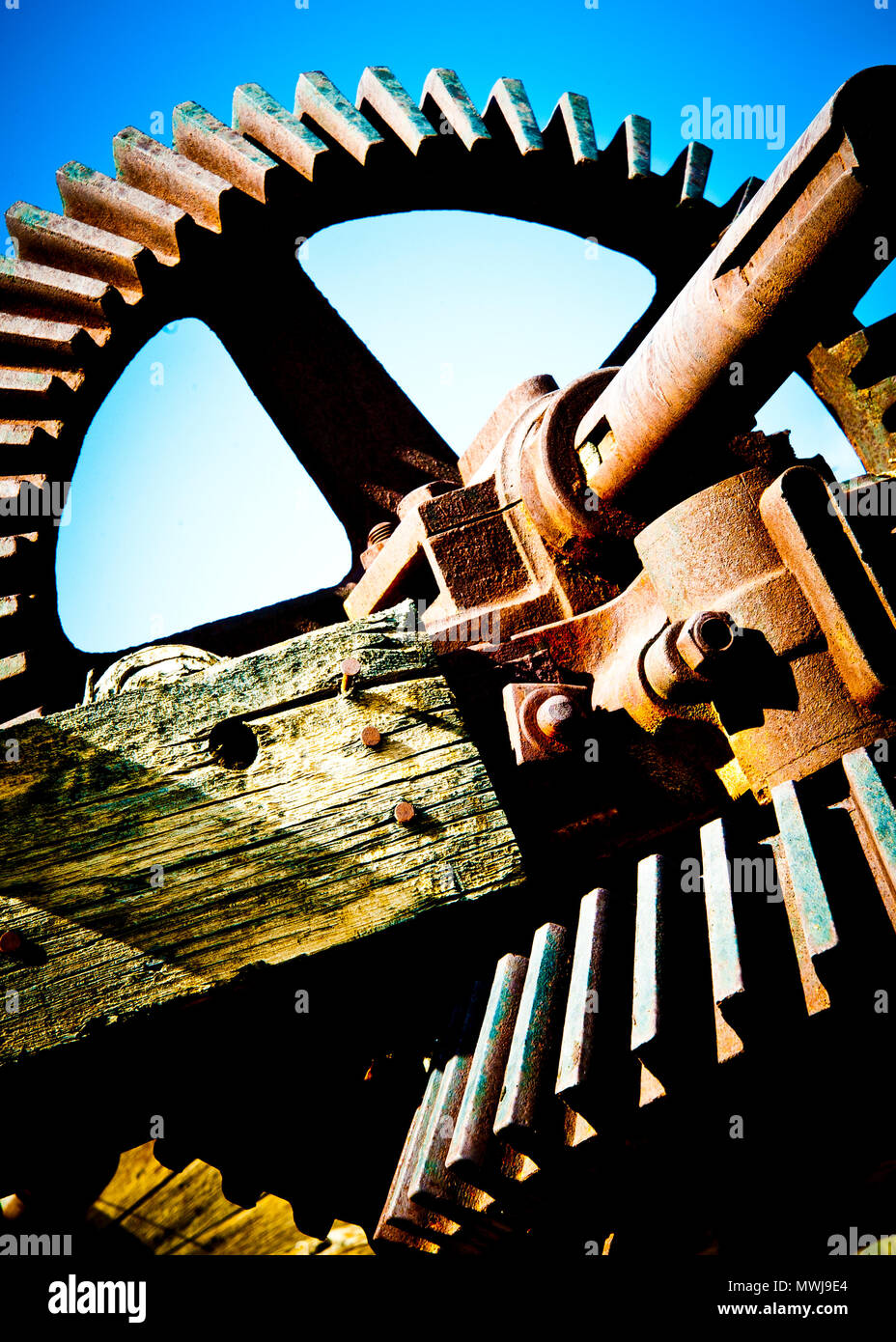 Künstlerische vertikale Ansicht aus einer vergangenen Alter von schweren Maschinenbau, Rosten alten Zahnrad und Antriebswelle, stillgelegter Bergbau Teile. Stockfoto