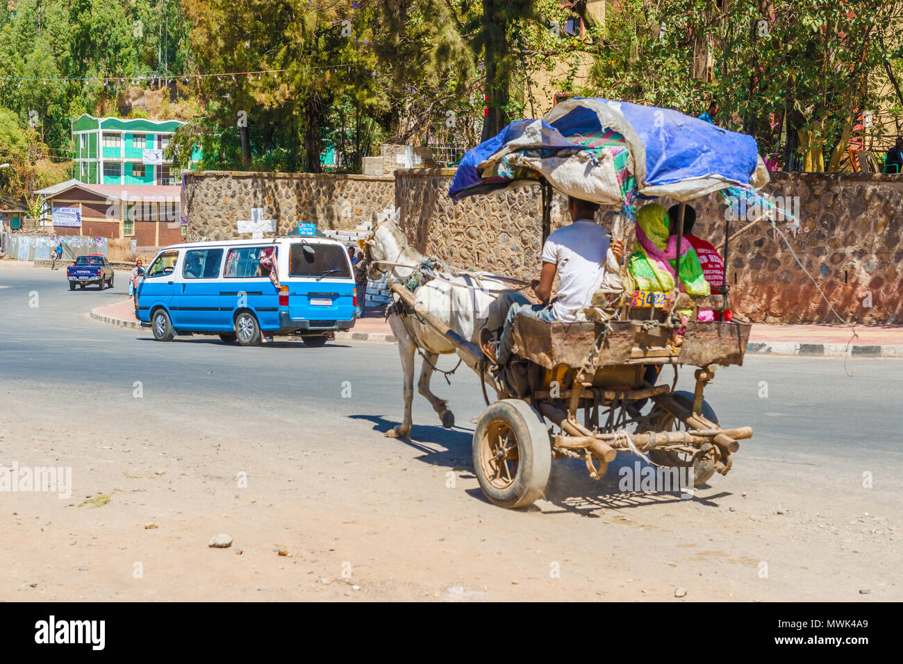 Gondar, Äthiopien - Februar 9, 2015: Straße in Gondar am frühen Nachmittag. Äthiopien. Menschen reiten in die Karre von Esel gezogen. Stockfoto