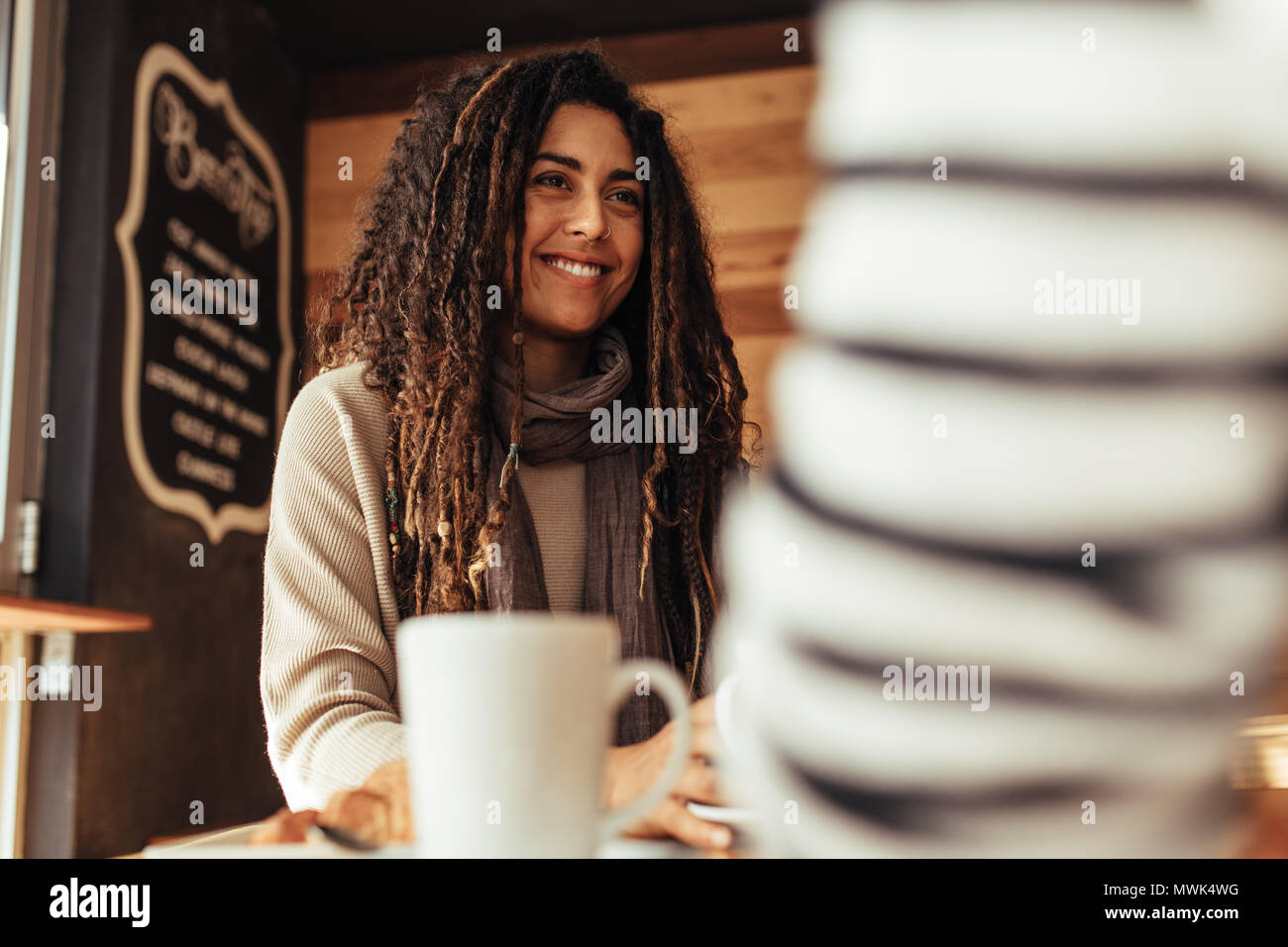Lächelnde Frau in einem Restaurant sitzen im Gespräch mit ihrer Freundin. Freunde in einem Café mit Kaffee am Tisch sitzen. Stockfoto