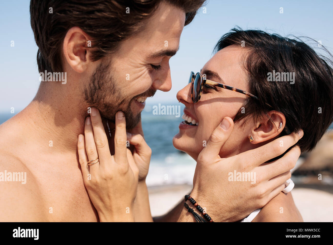 Paar jedes andere Holding stehen auf dem Strand zu küssen. Touristische Paar in eine glückliche und romantische Stimmung genießen einen Urlaub. Stockfoto