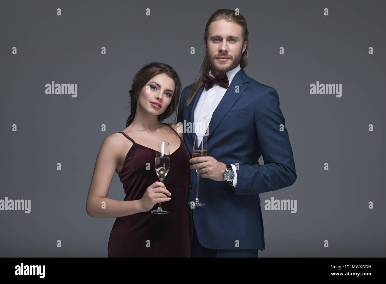 Junges Paar in Abendgarderobe holding Gläser mit Champagner und Kamera Stockfoto