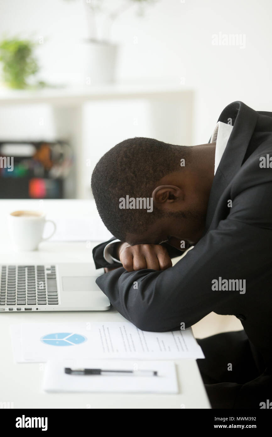 Überarbeitet African American in Nickerchen am Arbeitsplatz Stockfoto