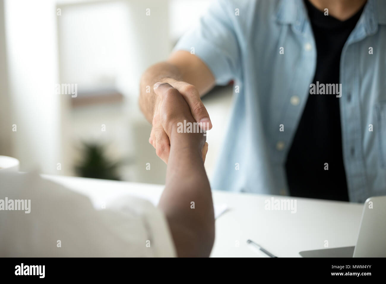 Nahaufnahme von Multirassischen Handshake über Büro Schreibtisch Stockfoto