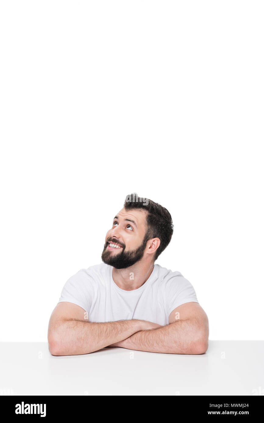 Schön lächelnden Mann sitzt am Tisch und Wegsehen auf Weiß isoliert Stockfoto