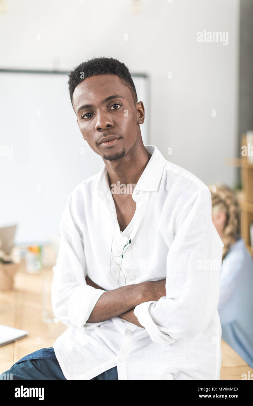 Portrait von nachdenklich afrikanische amerikanische Geschäftsmann mit verschränkten Armen an Kamera suchen Stockfoto