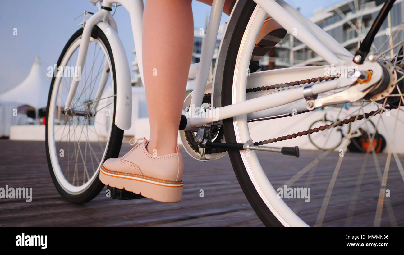 Nahaufnahme der Jungen stilvolle Mädchen in rosa Plattform Schuhe  Haferlschuhe und Rock Radfahren auf vintage Bike auf Holz- Damm. Frau auf  dem Fahrrad Stockfotografie - Alamy