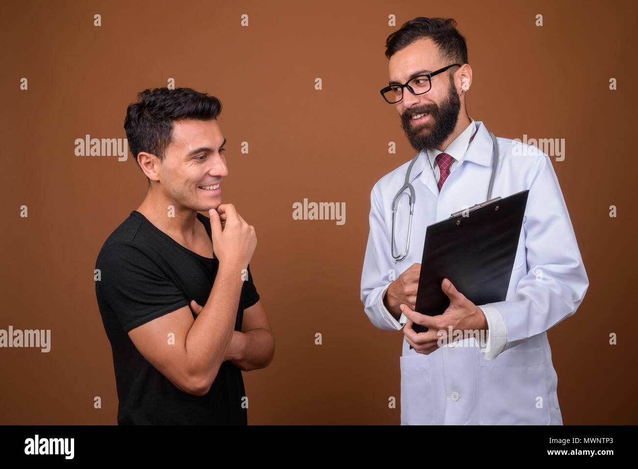 Junge Bartgeier persischen Mann Arzt mit jungen Hispanic Mann Patient Stockfoto