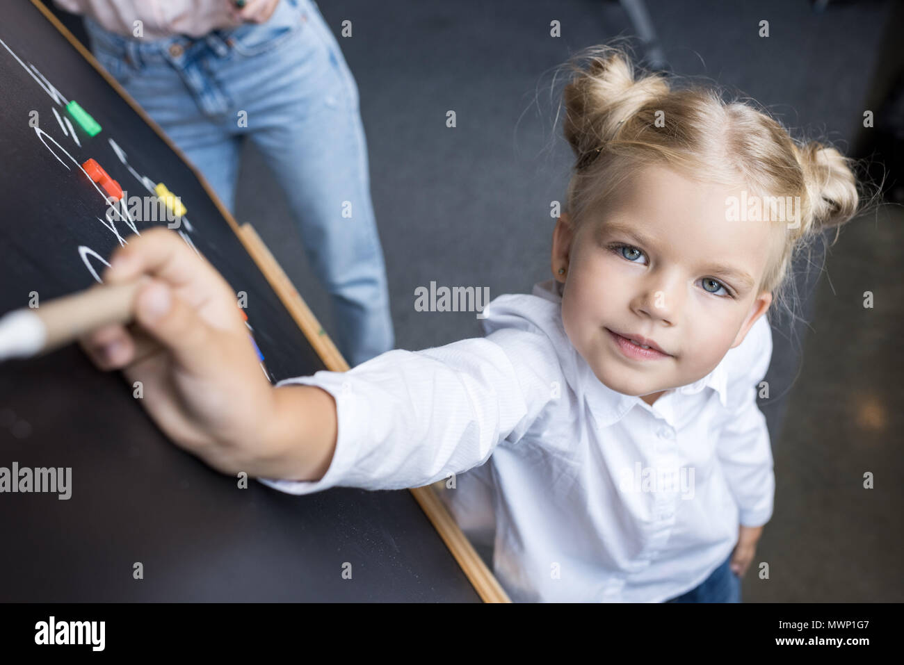 Adorable kleine Schulmädchen zeichnungsnummern am Schwarzen Brett Stockfoto