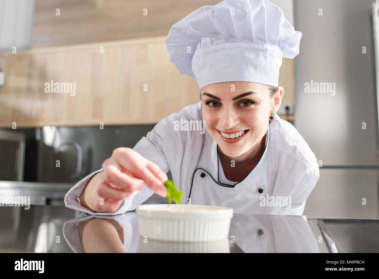 Köchin garnieren Teller auf Restaurant Küche Stockfoto