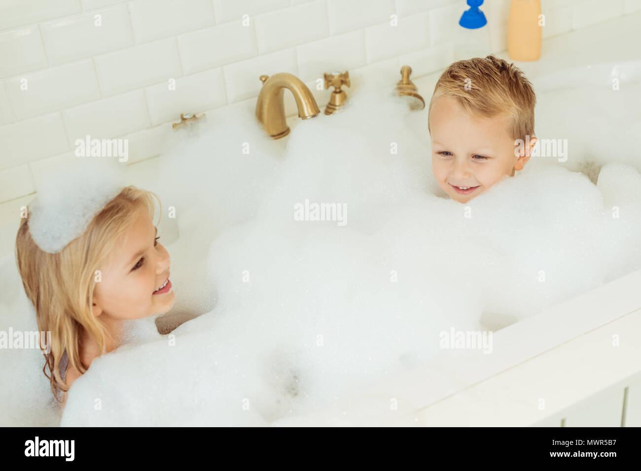 Hohe Betrachtungswinkel von entzückenden kleinen Kinder spielen zusammen in der Badewanne mit Schaum Stockfoto