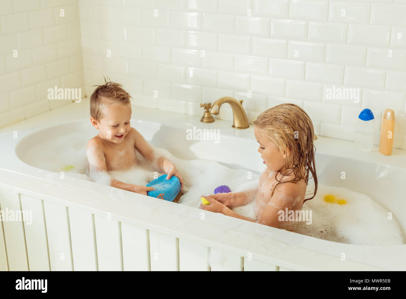 Adorable gerne kleine Kinder spielen zusammen in der Badewanne Stockfoto