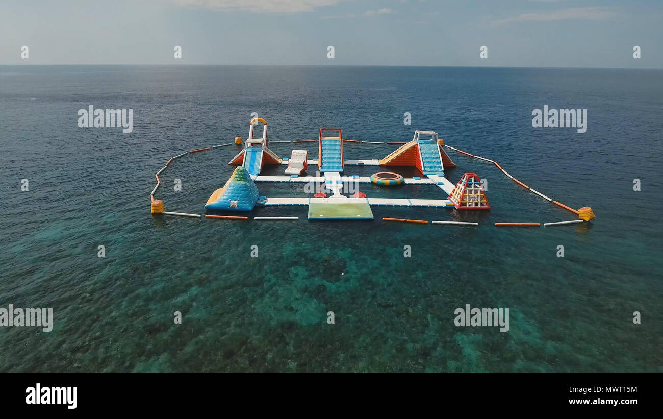 Luftaufnahme aufblasbare Floating Water Park im Meer. Mit Wasserrutschen und Attraktionen im Ozean Aquapark. Bali, Indonesien. Stockfoto