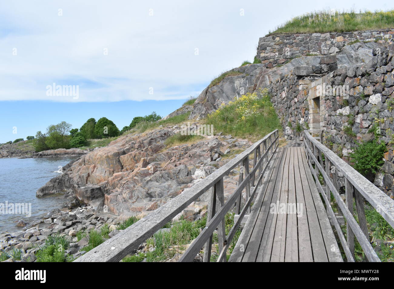 Holzbrücke auf Suomenlinna Insel. Küstenweg, Suomenlinna, Finnland Stockfoto