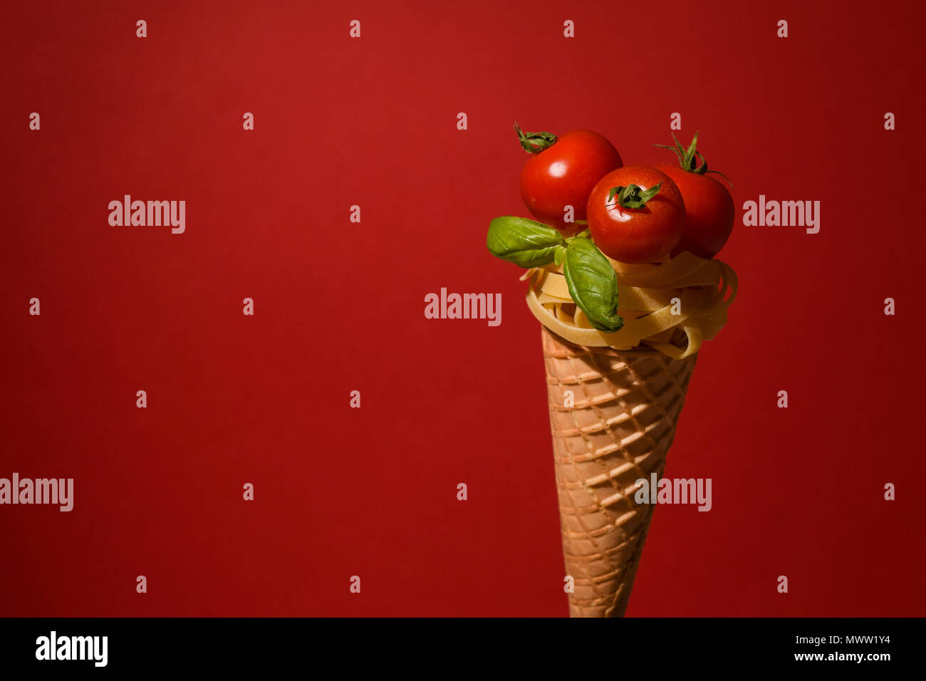 Tagliatelle mit Cherry Tomaten auf einem Kegel wie ein Eis Stockfoto