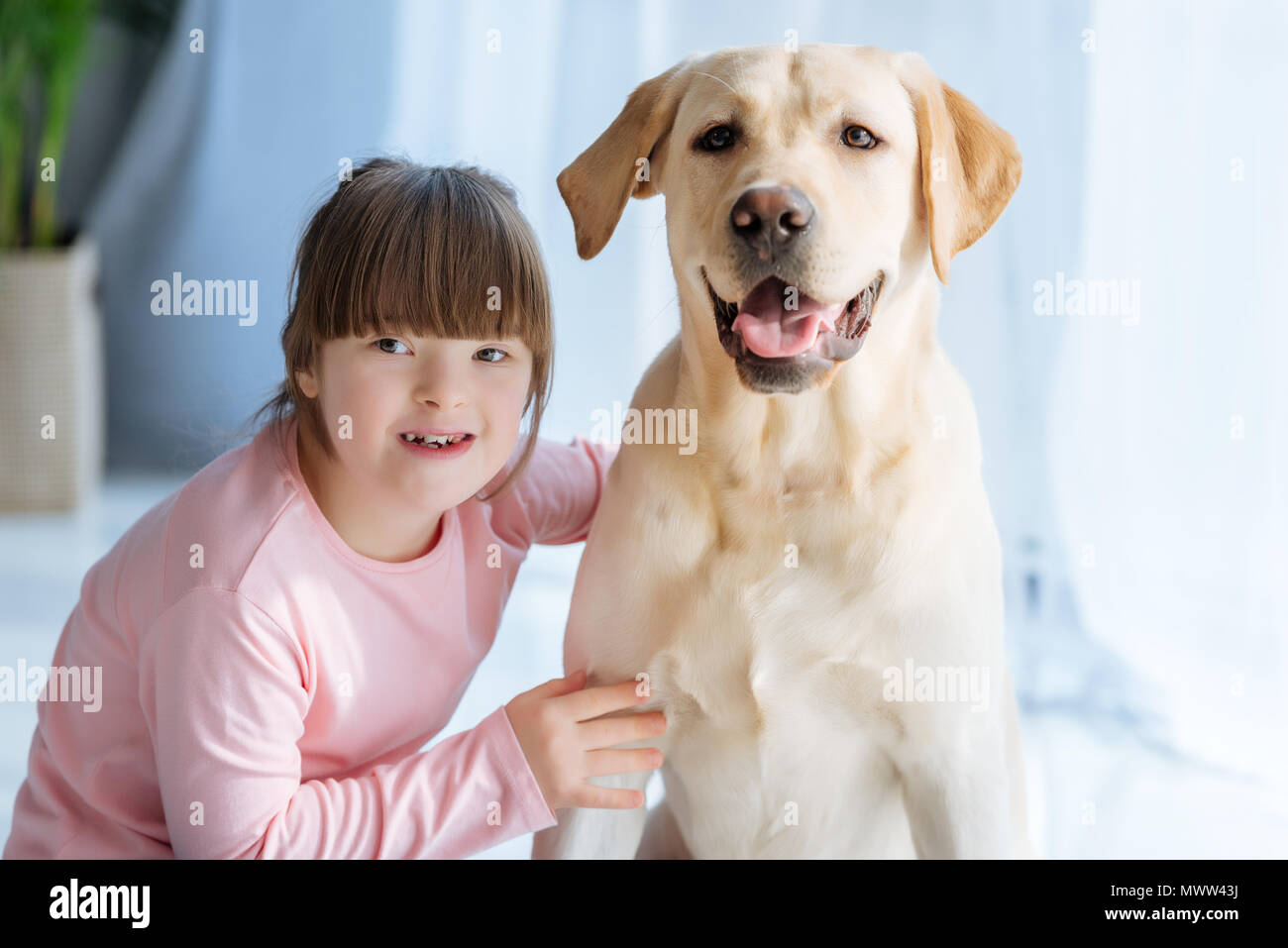 Glückliches Kind Mädchen mit Down-syndrom wtoabkommen Labrador Retriever Stockfoto
