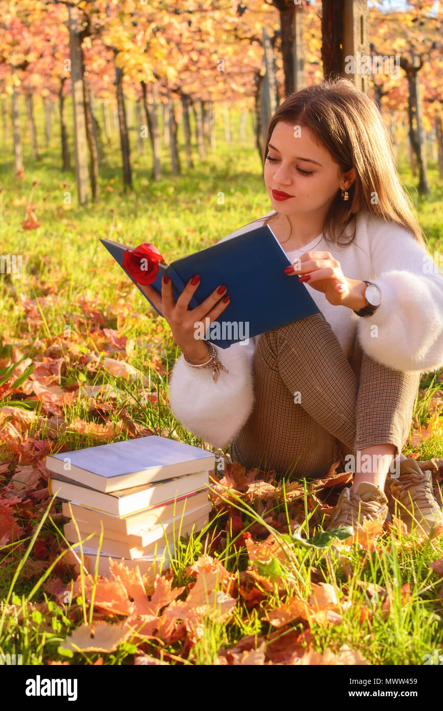Mädchen mit einem Buch in der Natur sitzen Stockfoto