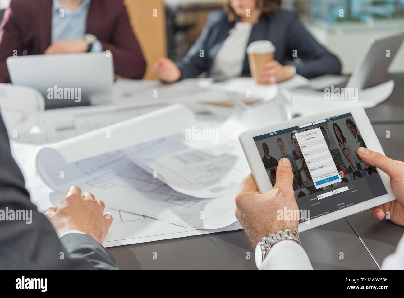 7/8 Schuß des Architekten tablet Mit Linkedin website auf dem Bildschirm während Konferenz Stockfoto