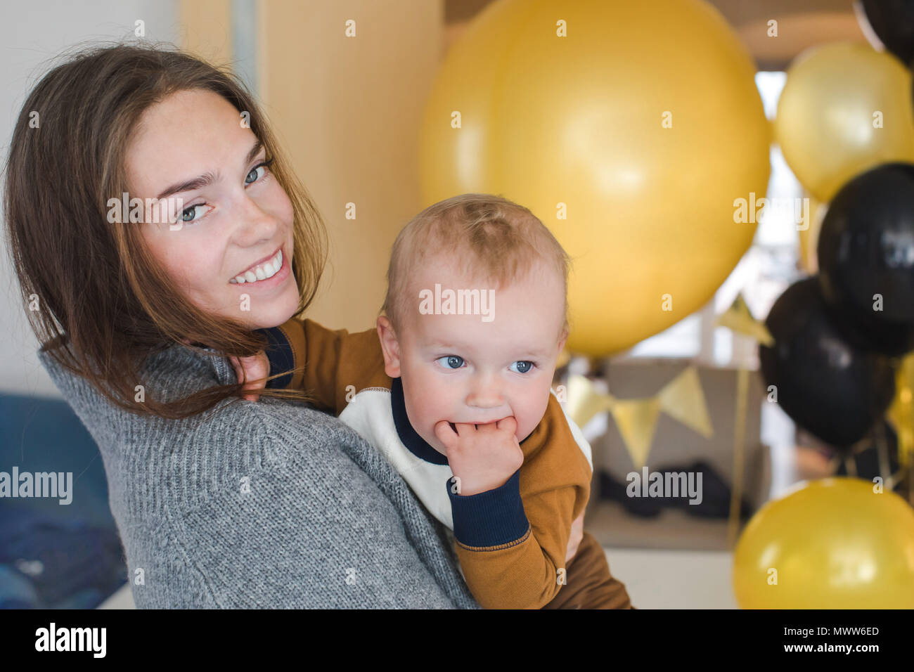 Fröhliche Frau mit Baby auf Party Stockfoto