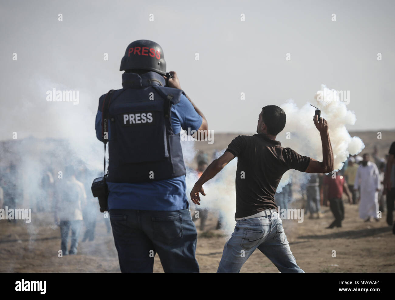 In Gaza. 01 Juni, 2018. Einen palästinensischen Demonstrant wirft wieder einen israelischen Tränengas Granate bei den Auseinandersetzungen in der Nähe der Grenze zwischen Israel und Gaza, Gaza, den 01. Juni 2018. Eine weibliche ehrenamtliche Sanitäter wurde getötet und mehr als 100 palästinensischen Demonstranten bei Zusammenstößen in der Nähe der Grenze mit Israel verletzt. Die Demonstranten wollen ihre Forderung für das Recht der palästinensischen Flüchtlinge im Nahen Osten zu Häusern, die sie im Krieg um die Schöpfung 1948 von Israel flohen zurück, um fortzufahren. Credit: nidal Alwaheidi/Pacific Press/Alamy leben Nachrichten Stockfoto