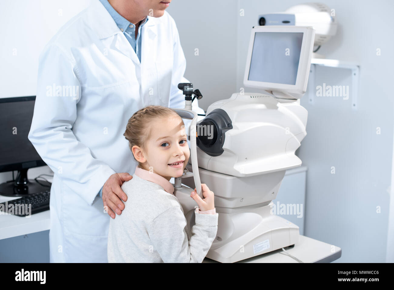 Zugeschnittenes Bild der Augenarzt und adorable Jugendlicher Kind in Klinik Stockfoto