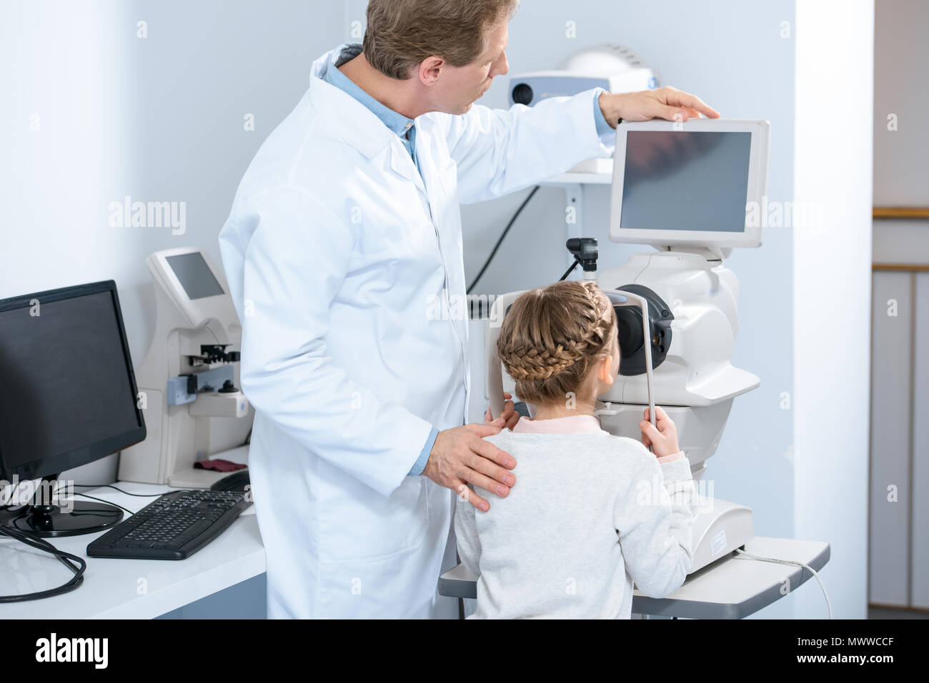 Rückansicht der Augenarzt untersuchen Vision von jugendlicher Kind in Klinik Stockfoto