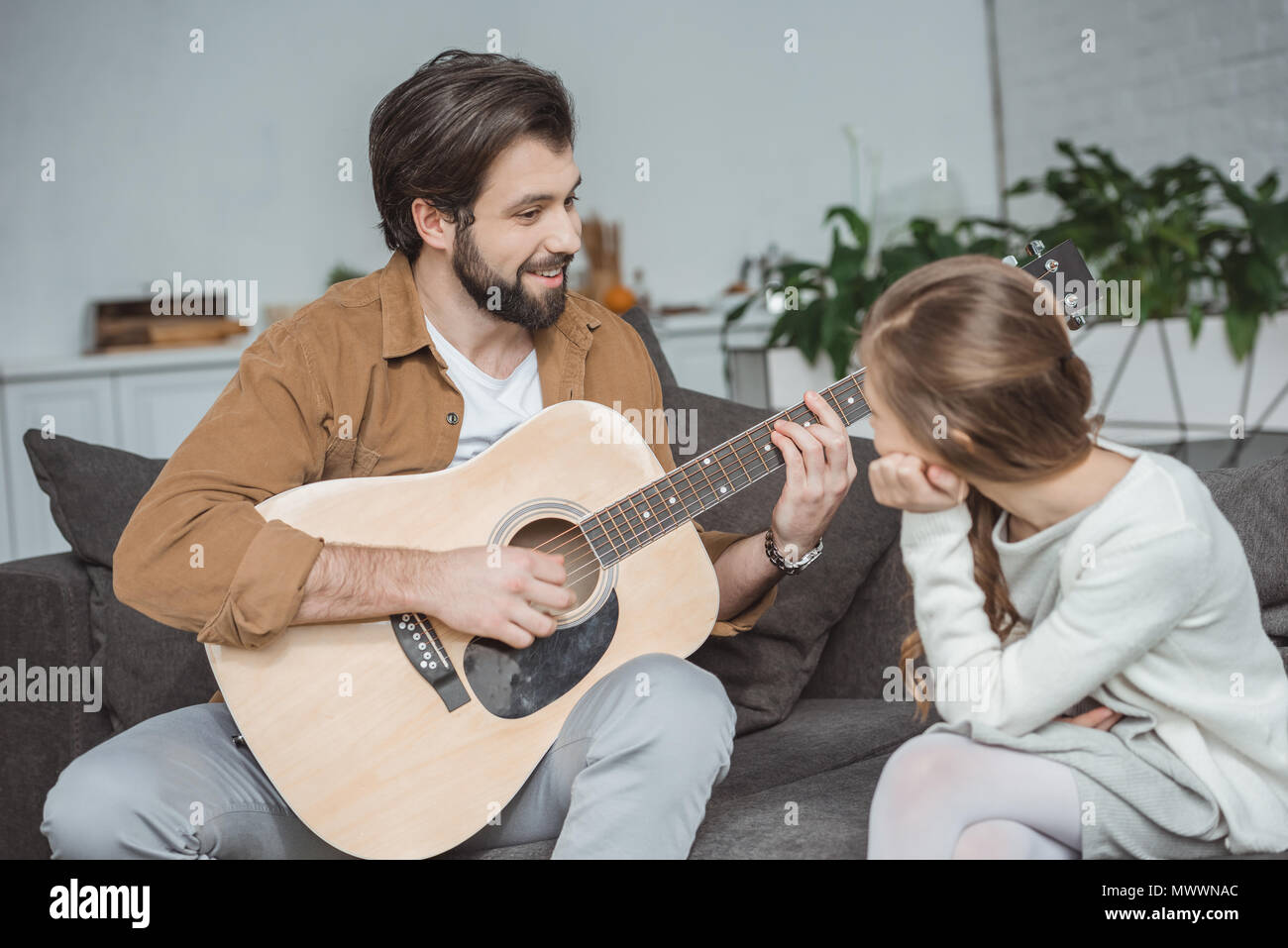 Lächelnd Vater mit Tochter wie Barre Akkord zu spielen Stockfoto