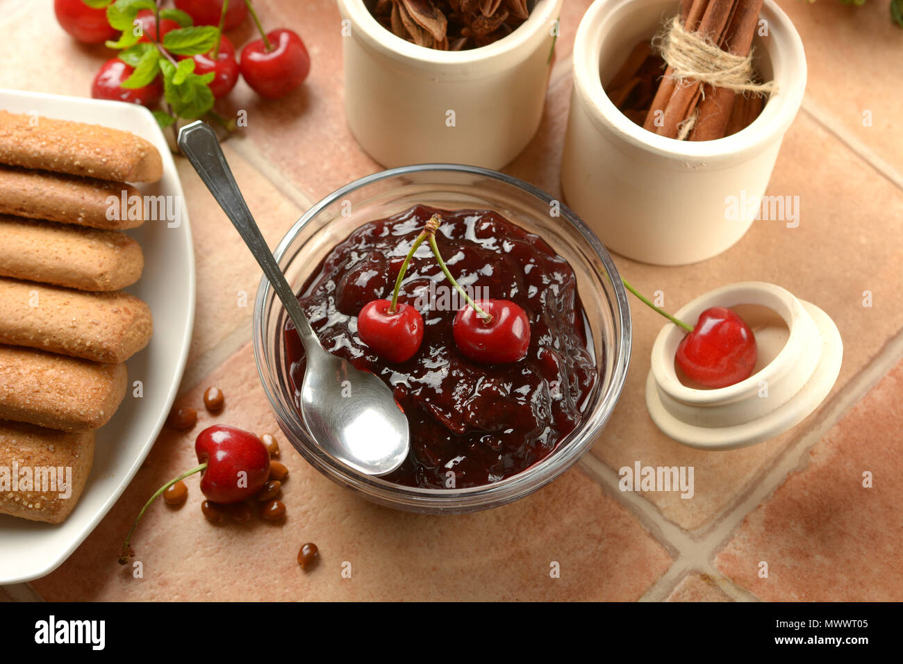 Cherry Marmelade im Glas Schale mit Früchten um: Detailansicht Stockfoto