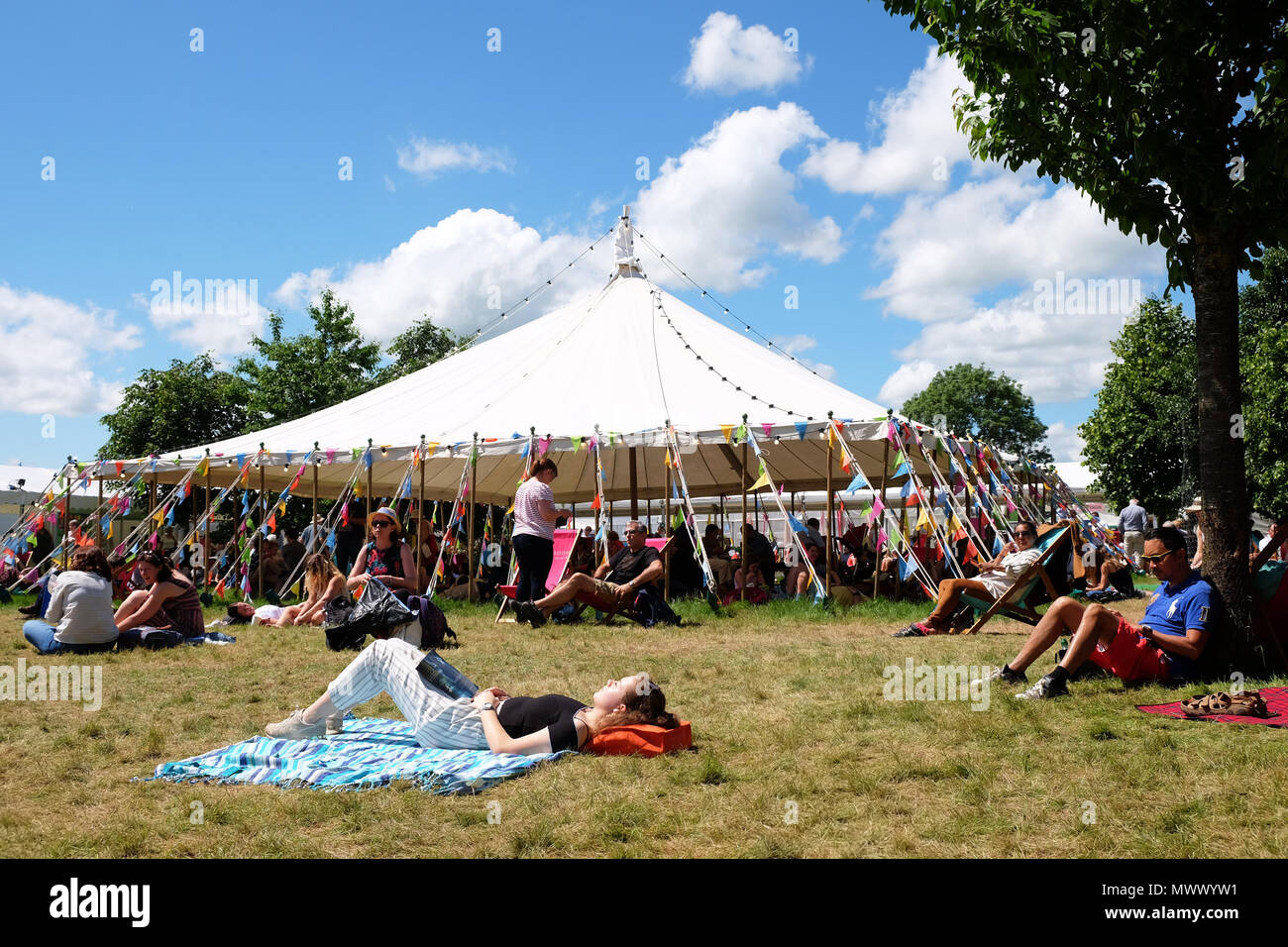 Das Heu, das auf Wye, UK. 2. JUNI 2018. - DE Wetter - Besucher genießen Sie die Gelegenheit zum Sitzen und in der warmen Sonne auf dem Festival Rasenflächen zwischen den Veranstaltungen und Sitzungen mit lokalen Temperaturen von 22 C - das Heu Festival weiterhin Sonntag, den 3. Juni - Foto Steven Mai/Alamy Live News entspannen Stockfoto