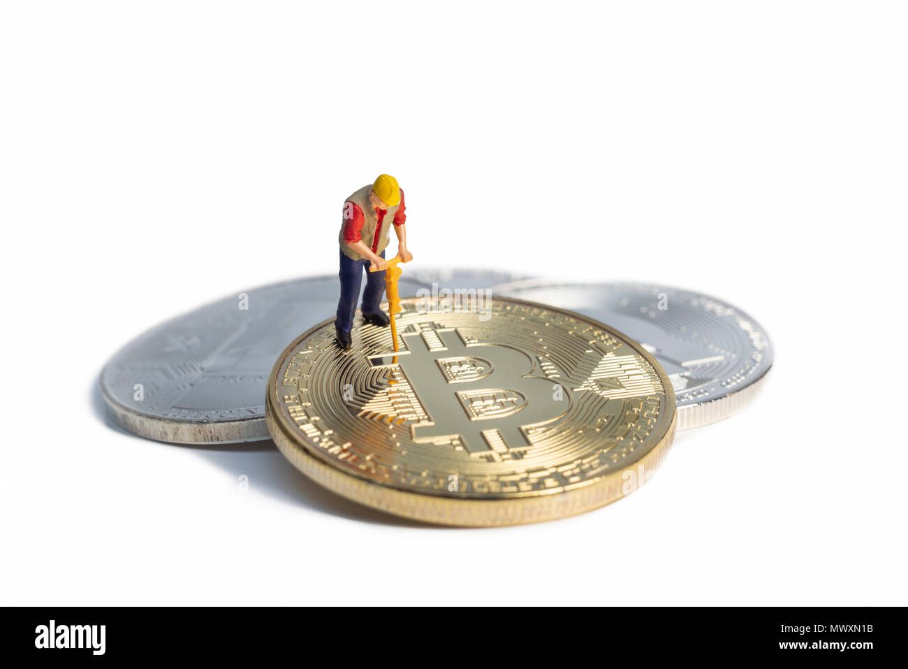 Miniatur Arbeiter Bergbau Bitcoin auf eine weiße Fläche Stockfoto