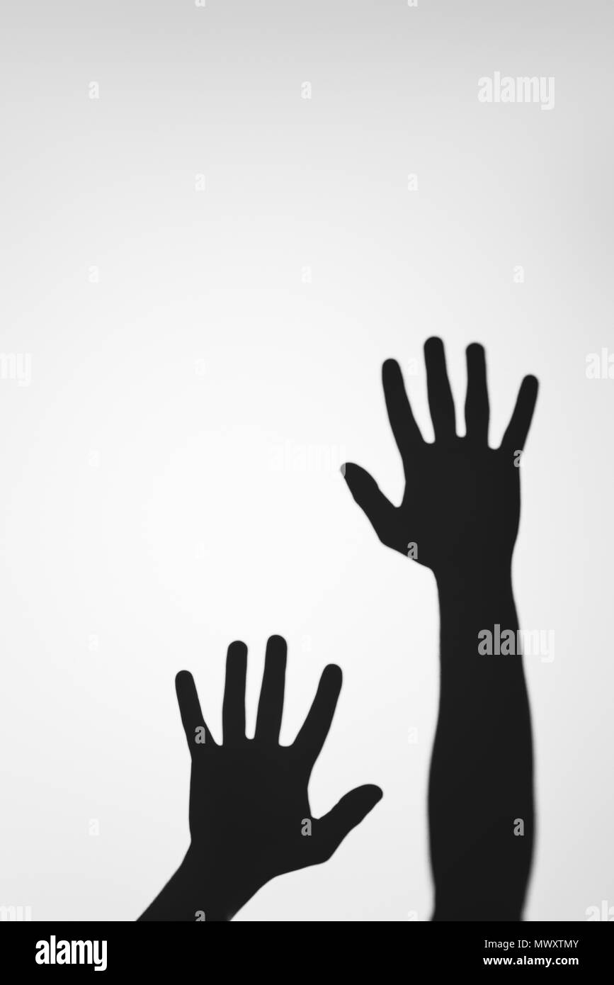 Unheimlich geheimnisvolle Schatten der menschlichen Hände auf Grau Stockfoto
