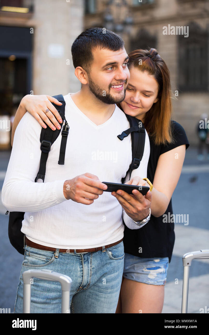 Froh, junge weibliche und männliche Touristen zusammen am Handy suchen Stockfoto