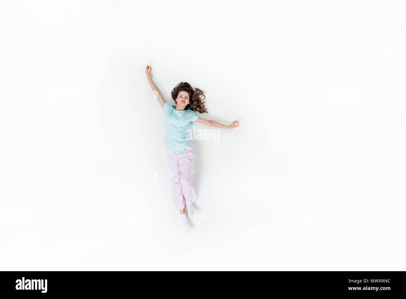 Blick von oben auf die schöne junge Frau im Schlafanzug isoliert Stretching auf Weiß Stockfoto