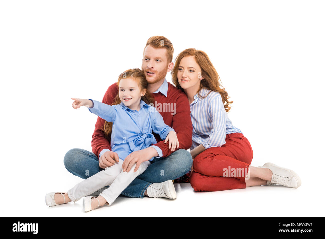 Schöne rothaarige Familie mit einem Kind sitzen zusammen und Wegsehen auf Weiß isoliert Stockfoto