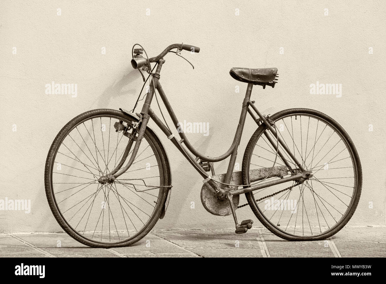 Oldtimer-Bike lehnte sich in Montisi an der Wand und nahm im Mai an der Eroica Montalcino, Siena, Toskana, Italien Teil - schwarz-weiß monochrom Stockfoto