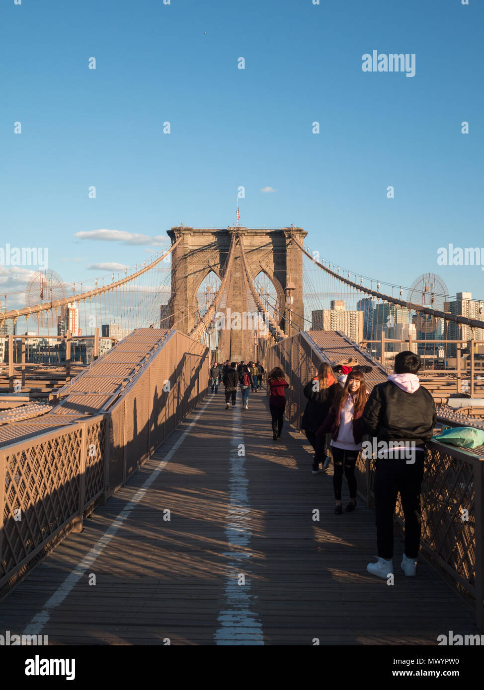 Menschen überqueren Sie die Brooklyn Bridge im Abendlicht Stockfoto