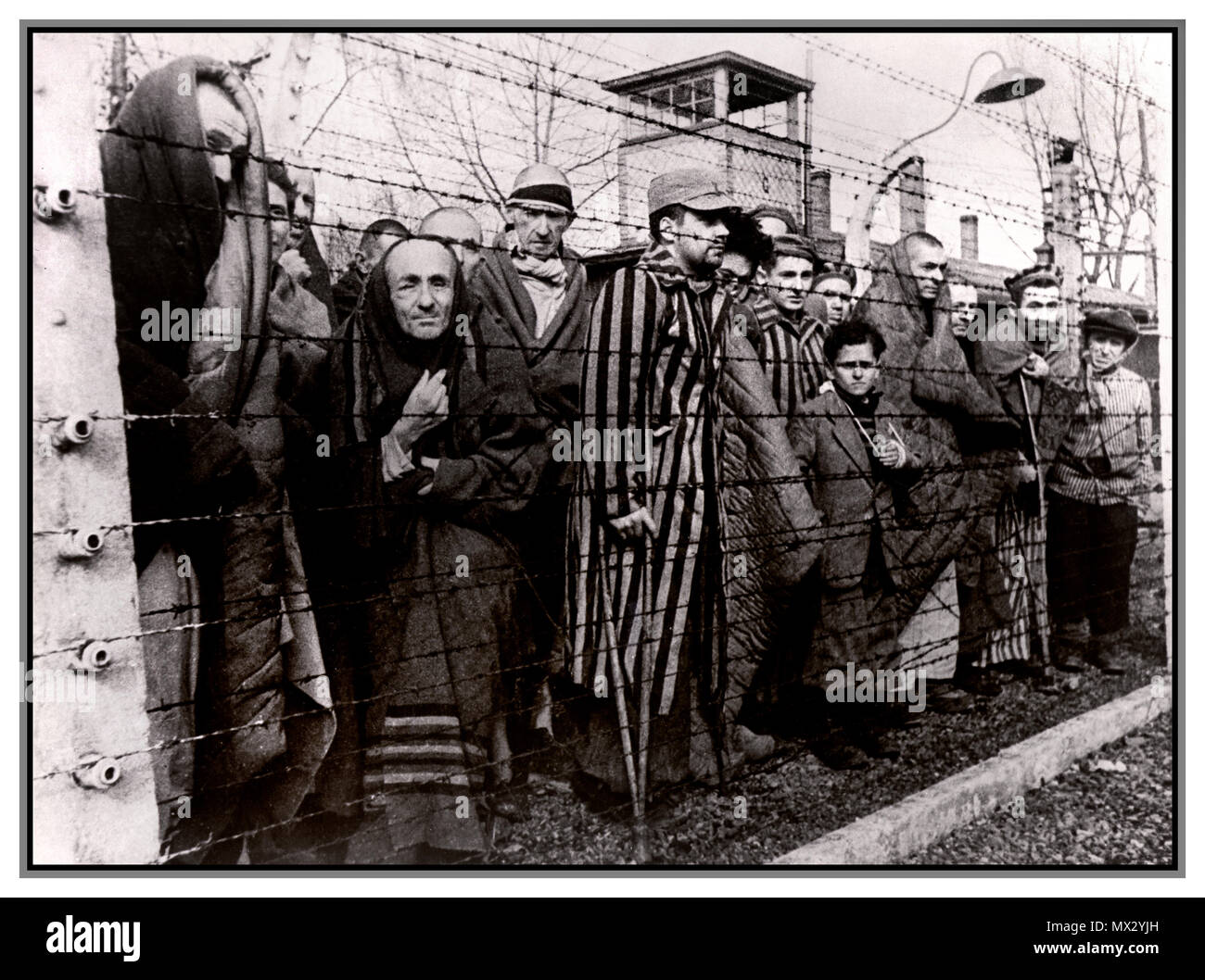 1940 Holocaust WW2 Nazis Konzentrationslager Auschwitz-Birkenau. Männliche Gefangene hinter Stacheldraht elektrifiziert bei eisigen Gefängnis statt beengt erniedrigenden unmenschlichen Bedingungen. Dieses düstere emotionslos Bild wurde durch ihre Befreier 1945 aufgenommen. Mehr als 1,1 Millionen Menschen starben in Auschwitz, darunter fast eine Million Juden. Diejenigen, die nicht direkt mit Gaskammern geschickt wurden zu harten Zwangsarbeit verurteilt. Das Konzentrationslager Auschwitz Komplex war entscheidend für die Durchführung der NS-Plan für die "endgültigen Lösung." Auschwitz seine Spuren hinterlassen als einer der berüchtigsten Vernichtungslager des Zweiten Weltkriegs Stockfoto