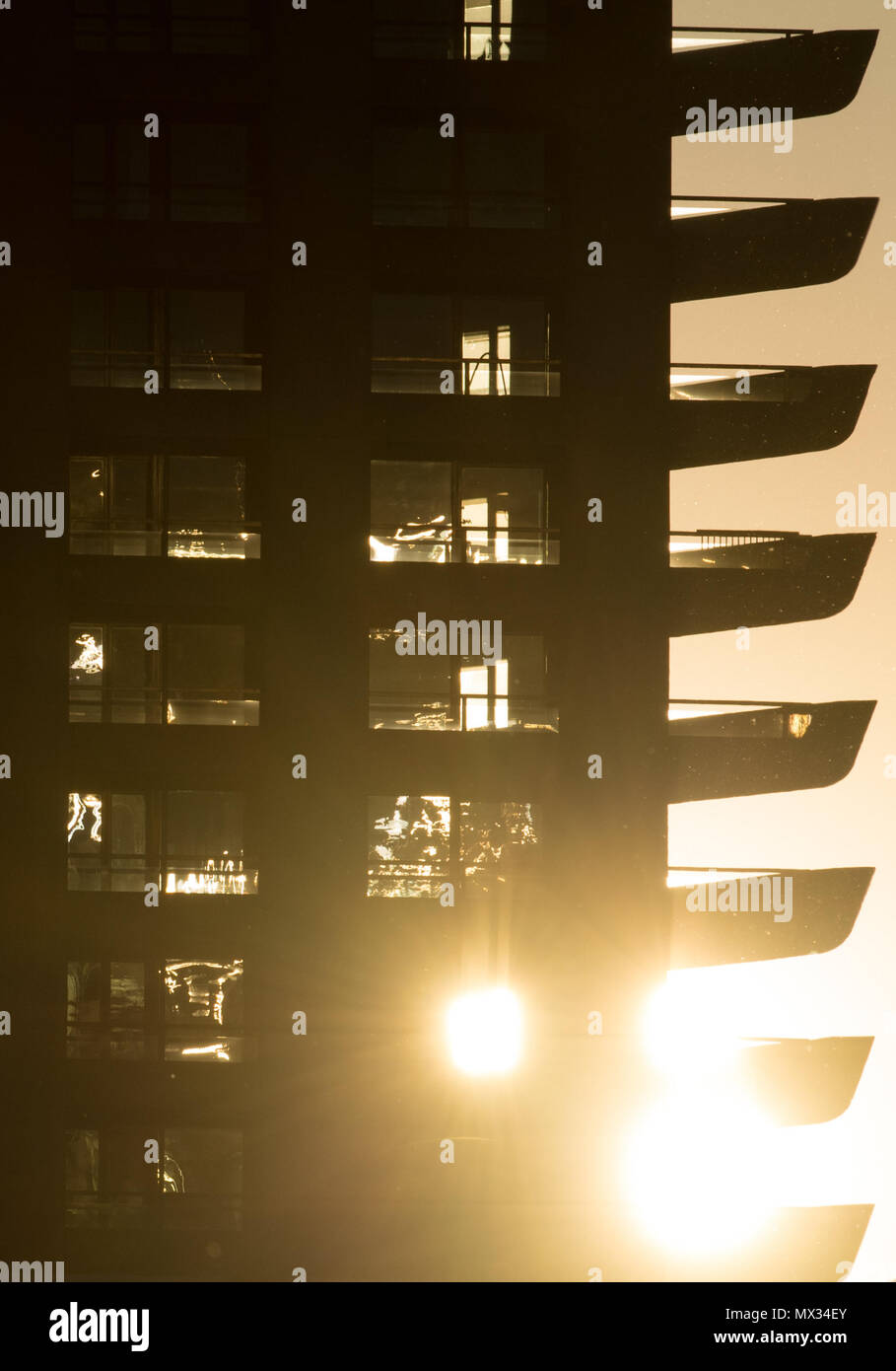 Die untergehende Sonne führt hinter dem Barbican Centre in London. Stockfoto