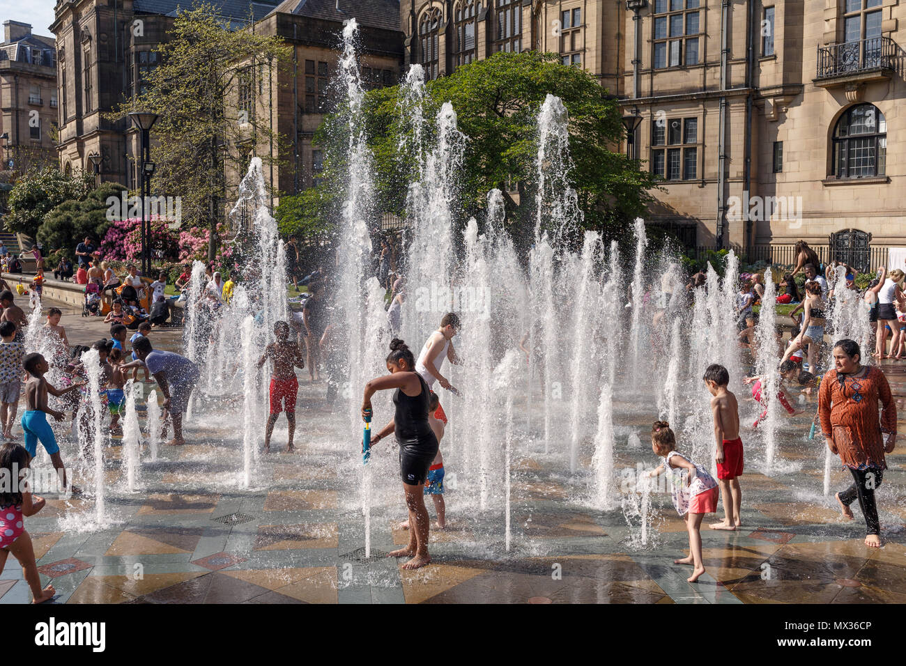 Kinder, die in einem Brunnen an einem der heißesten Tage des Jahres in Großbritannien. Sheffield Peace Gardens, Kinder, die spielen, Wasserfontänen. Stockfoto