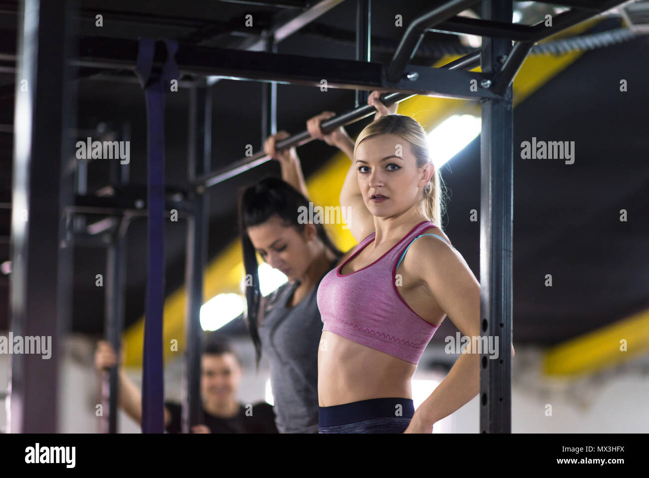 Gruppe junge muskulöse Athleten Zug tut ups auf der horizontalen Leiste als Teil der Cross Fitness Training Stockfoto