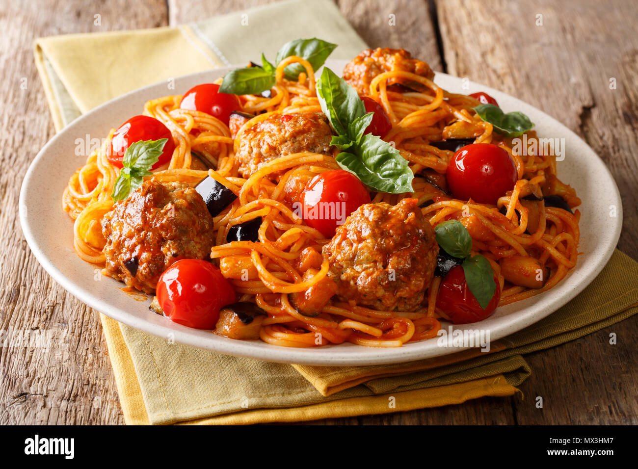 Köstliches Abendessen: Fleischbällchen mit Pasta Spaghetti, Auberginen und Tomaten close-up auf einem Teller auf dem Tisch. Horizontale Stockfoto