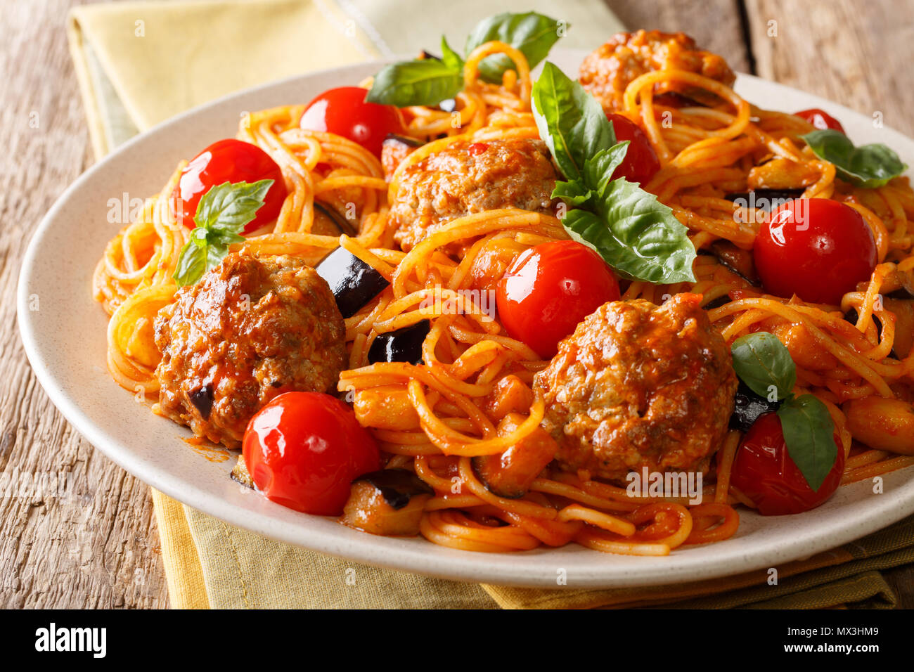 Gebratenes Fleisch Kugeln und Pasta Spaghetti mit Auberginen, Käse in Tomatensauce close-up auf einem Teller auf dem Tisch. Horizontale Stockfoto
