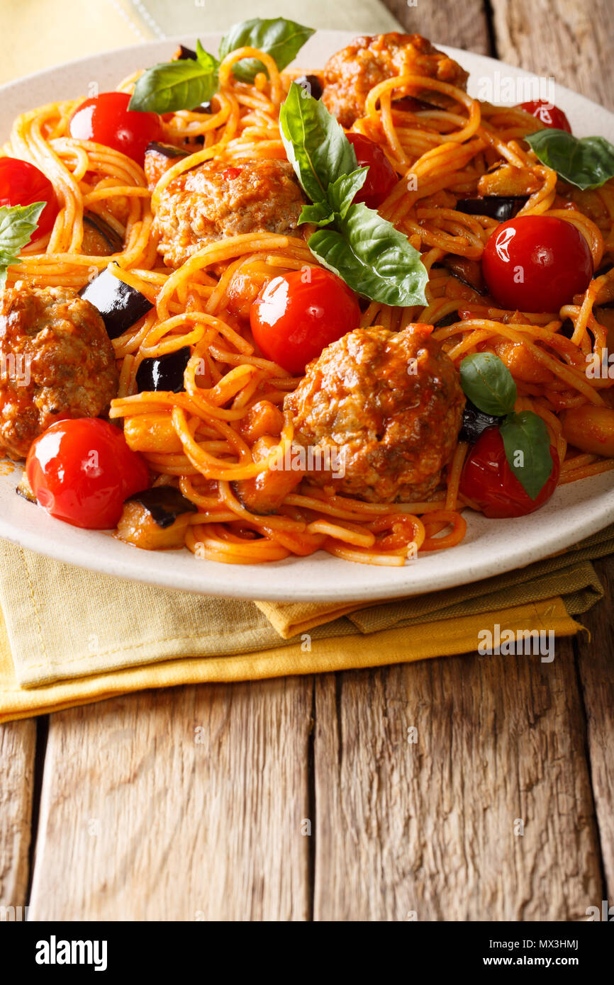 Italienische amerikanische Pasta Spaghetti mit Fleischbällchen, Gemüse in Tomatensauce close-up auf einem Teller auf dem Tisch. Vertikale, rustikalen Stil Stockfoto