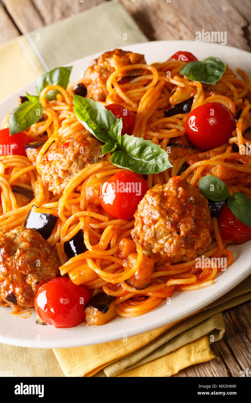 Spaghetti mit Fleischbällchen, Gemüse in Tomatensauce close-up auf einem Teller auf dem Tisch. Vertikale, rustikalen Stil Stockfoto