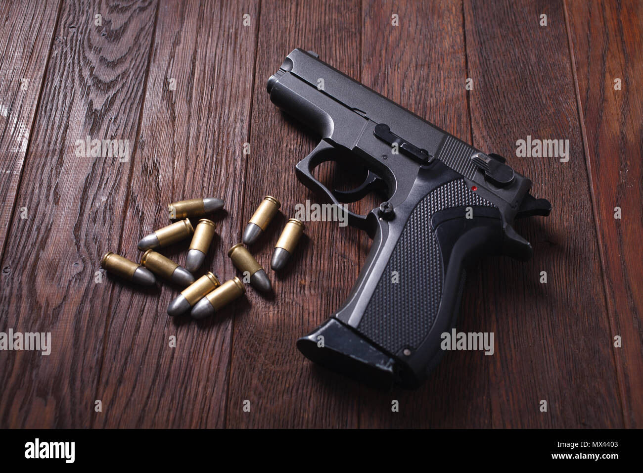 Pistole mit Patronen auf hölzernen Tisch Stockfoto